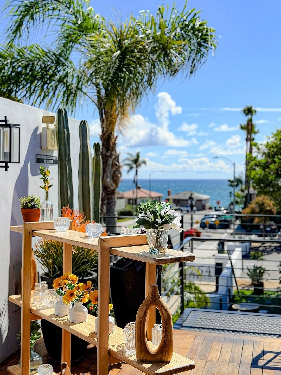 A table on The Deck at 264 Fresco, ocean and palms beyond