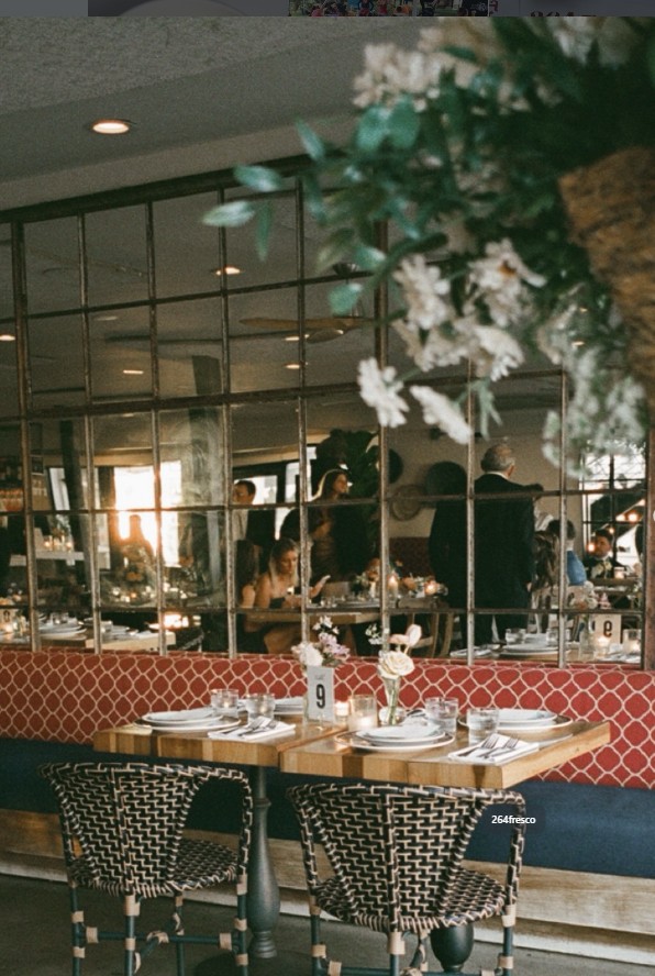 The main dining room at 264 Fresco — set tables, woven chairs, and the window wall