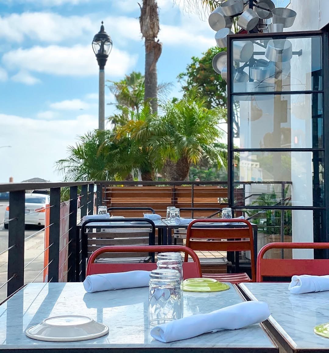 The front patio at 264 Fresco — umbrellas, plants, and tables in the village