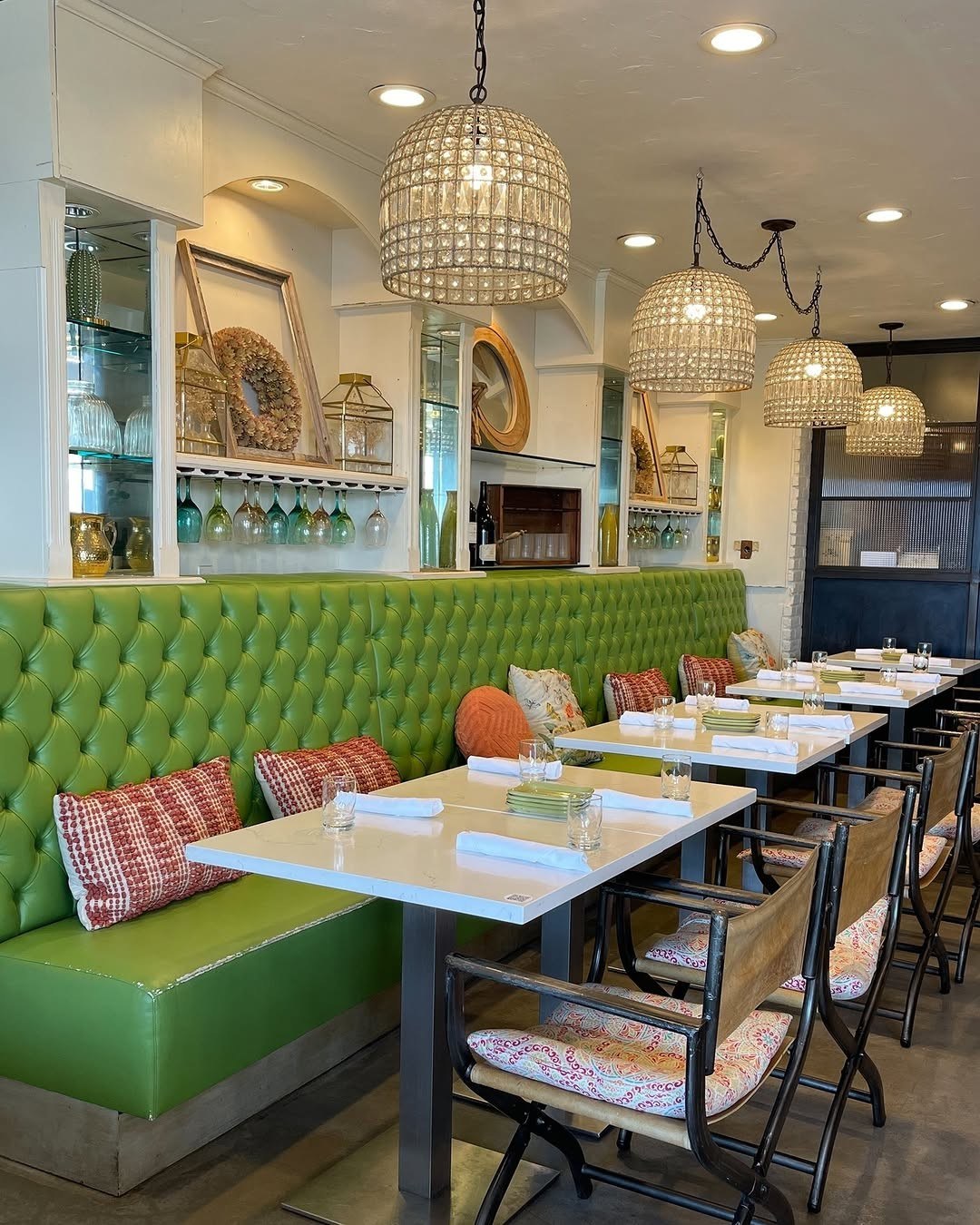 The Green Room at 264 Fresco — tufted banquettes, globe lights, and wine on the table